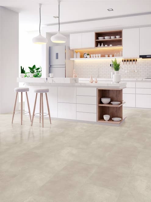 White modern kitchen with bright natural light, two stools by island, and cream stone/concrete look vinyl tiles