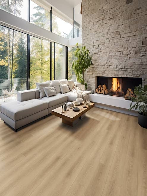 Spacious, natural, earthy living room with large stone fireplace, couch, and large floor-to-ceiling windows