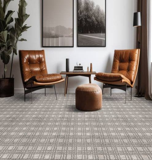 Modern home seating area with two brown leather chairs and an ottoman on a gray plaid geometric carpet