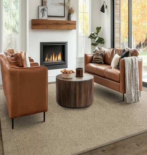 Modern living room with two leather couches and a coffee table before a white brick fireplace