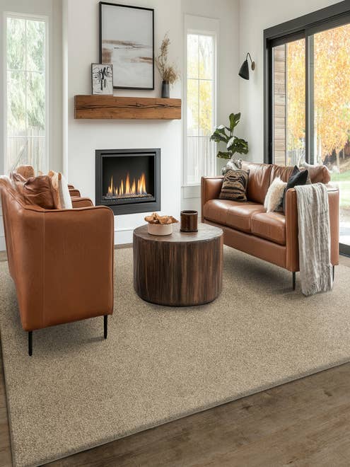 Modern living room with two leather couches and a coffee table before a white brick fireplace