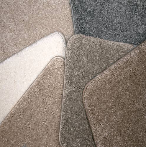 Assorted bound solid tan, white, or gray textured carpet samples