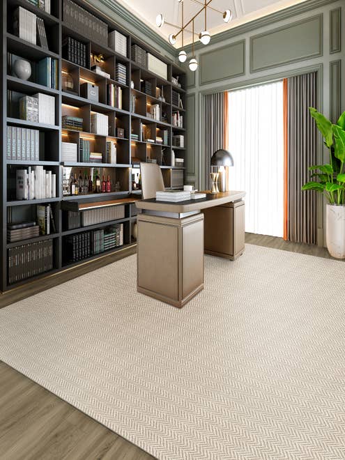 Home study with built-in cabinets and traditional desk sitting atop a tan geometric patterned area rug