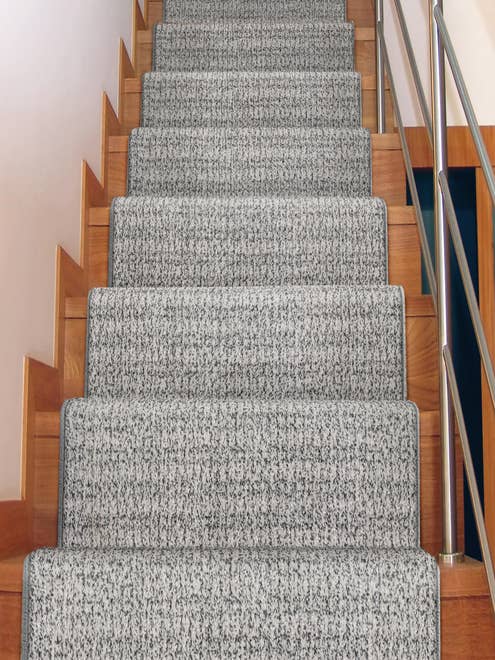 Solid plaid gray carpet runner down warm-toned wood staircase
