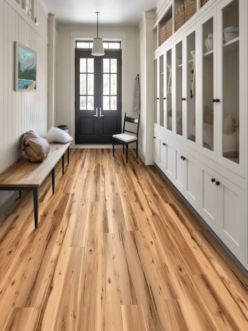 Farmhouse-inspired entry hall with floor-to-ceiling built-in cabinets, wooden bench, chair, and clean rustic woodgrain floor