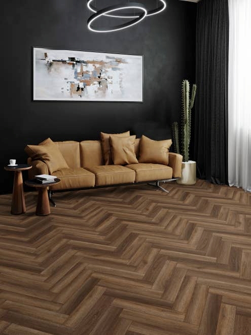 Dramatic seating area with mid-century modern furniture, black wall, cactus, and herringbone wood-look floor