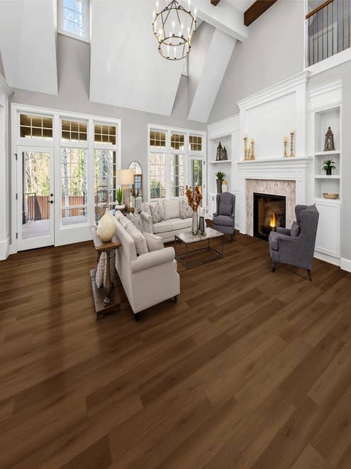 Modern contemporary room with two couches and two armchairs before a fireplace, with built-in shelves, high ceilings, and large windows, with rich tonal Brownstone floor