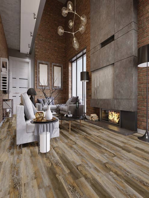 Luxe industrial studio apartment with sofas by fireplace, with globe light fixtures, exposed brick walls, and distressed Vintage Harvest LVP flooring