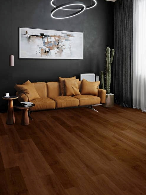 Tan couch, cactus, and side tables under large modern painting on black wall, with reddish brown woodgrain LVP flooring