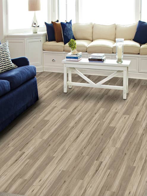 Cream sofa, blue loveseat, and coffee table in bright living room with light gray Timber Land Dockside LVP floor