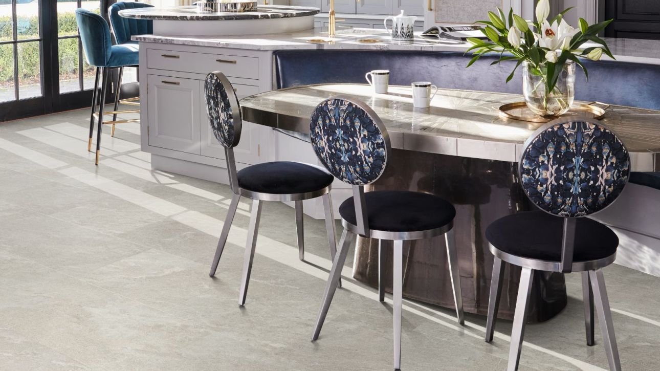Kitchen with large windows, pendant lights, oversized island, bar stools, and built-in breakfast bench with table and chairs