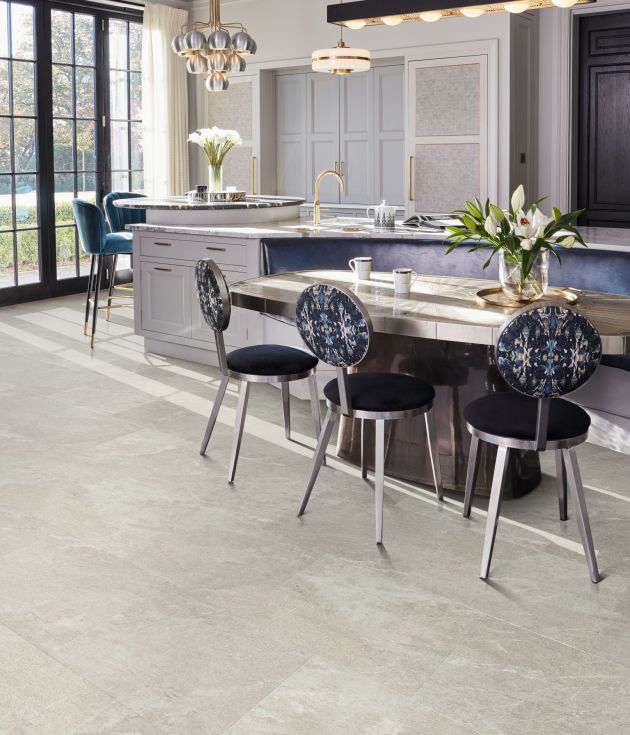 Kitchen with large windows, pendant lights, oversized island, bar stools, and built-in breakfast bench with table and chairs