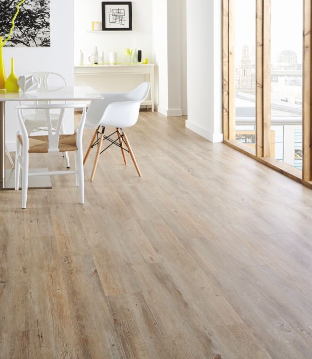 Modern dining area with table, yellow vase, and artwork in bright space with pale oak floor