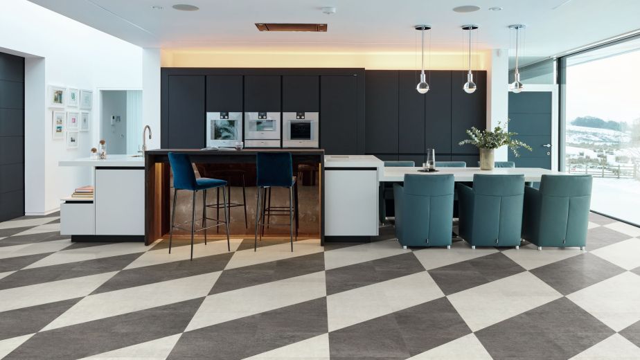 Blue kitchen cabinetry with island and attached eating area with gray and white checkered tile floor