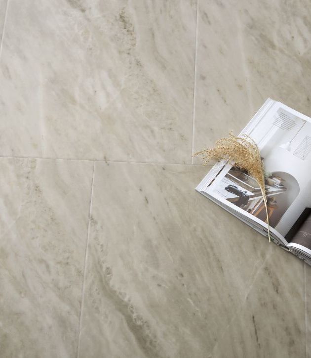 Open magazine and tuft of dried grass over gray marble tile floor